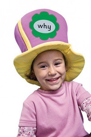 A little girl wearing a hat with the word " why " written on it.